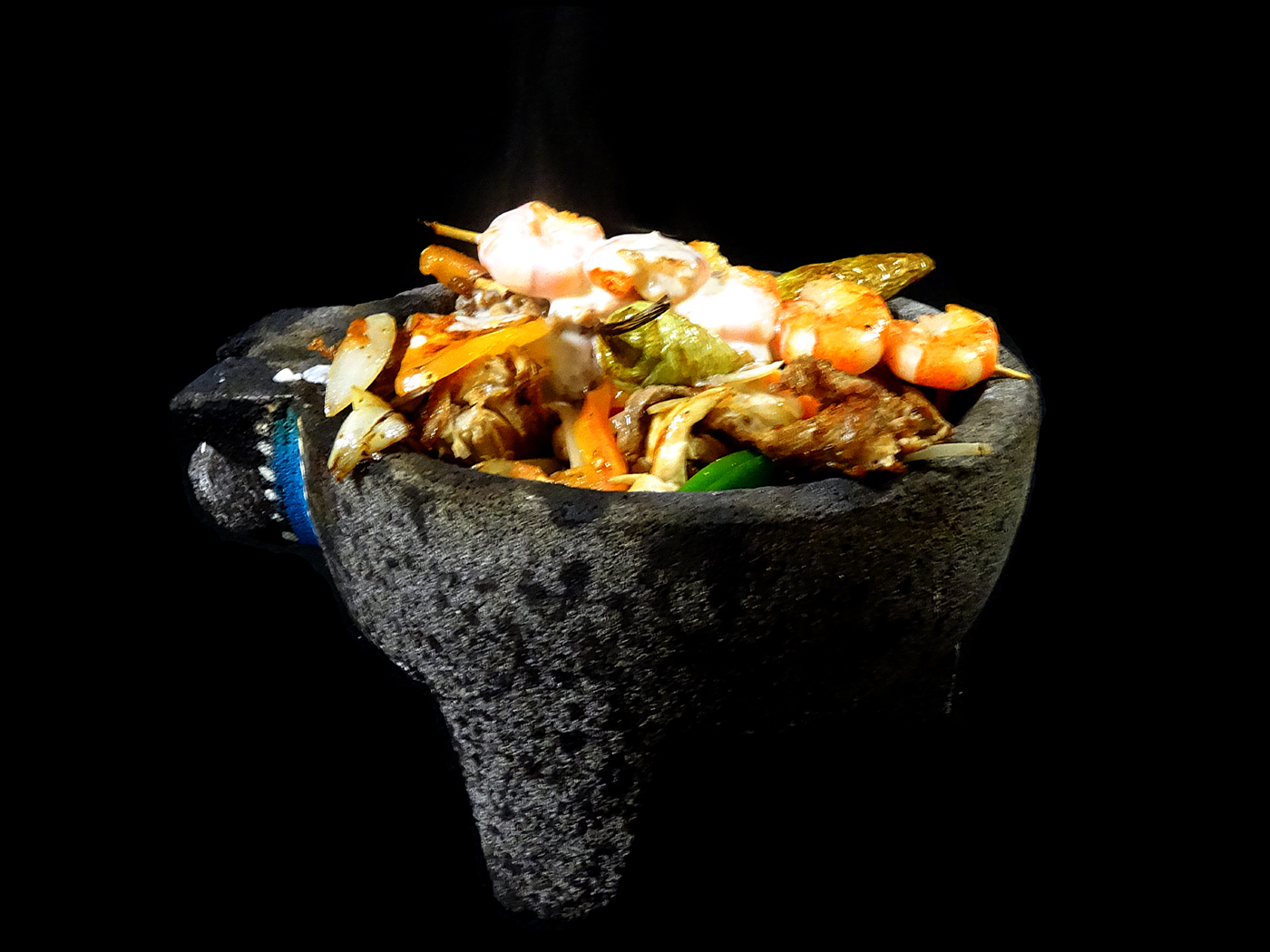 The Don Julio Especial: steak, grilled chicken, pork and jumbo shrimp steaming in a black stone mortar.