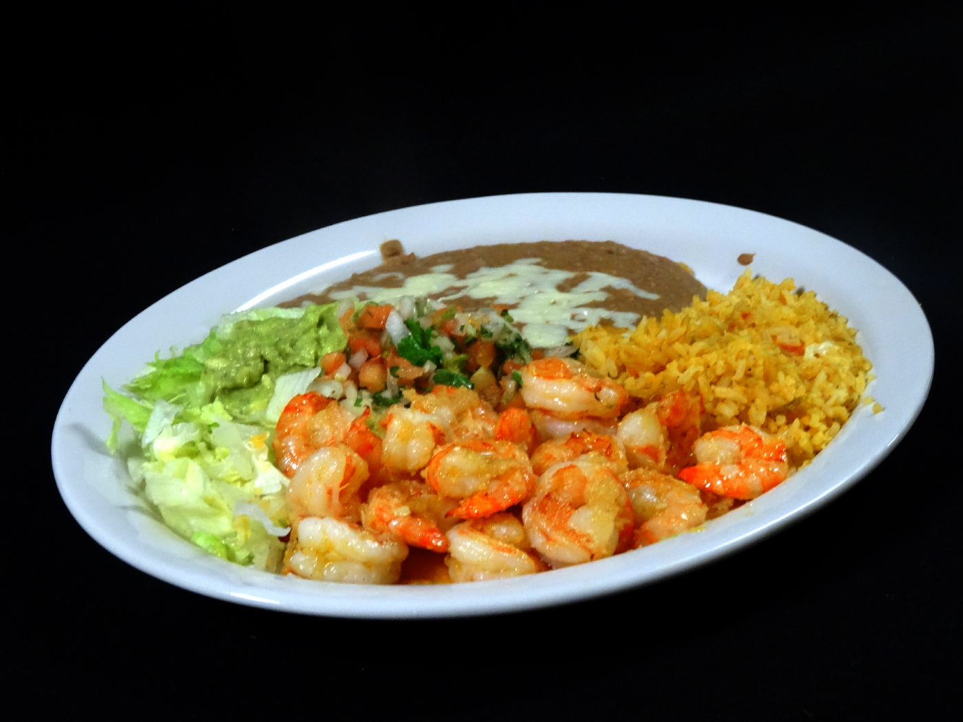 Shrimp served with Spanish rice, refried beans, guacamole, pico de gallo and lettuce.